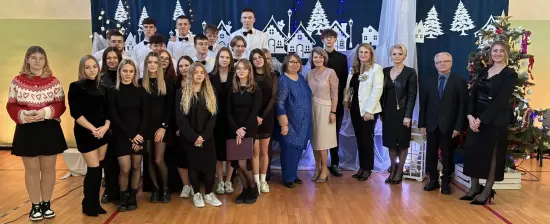 Dyrekcja wraz z uczniami w tle dekoracja świąteczna